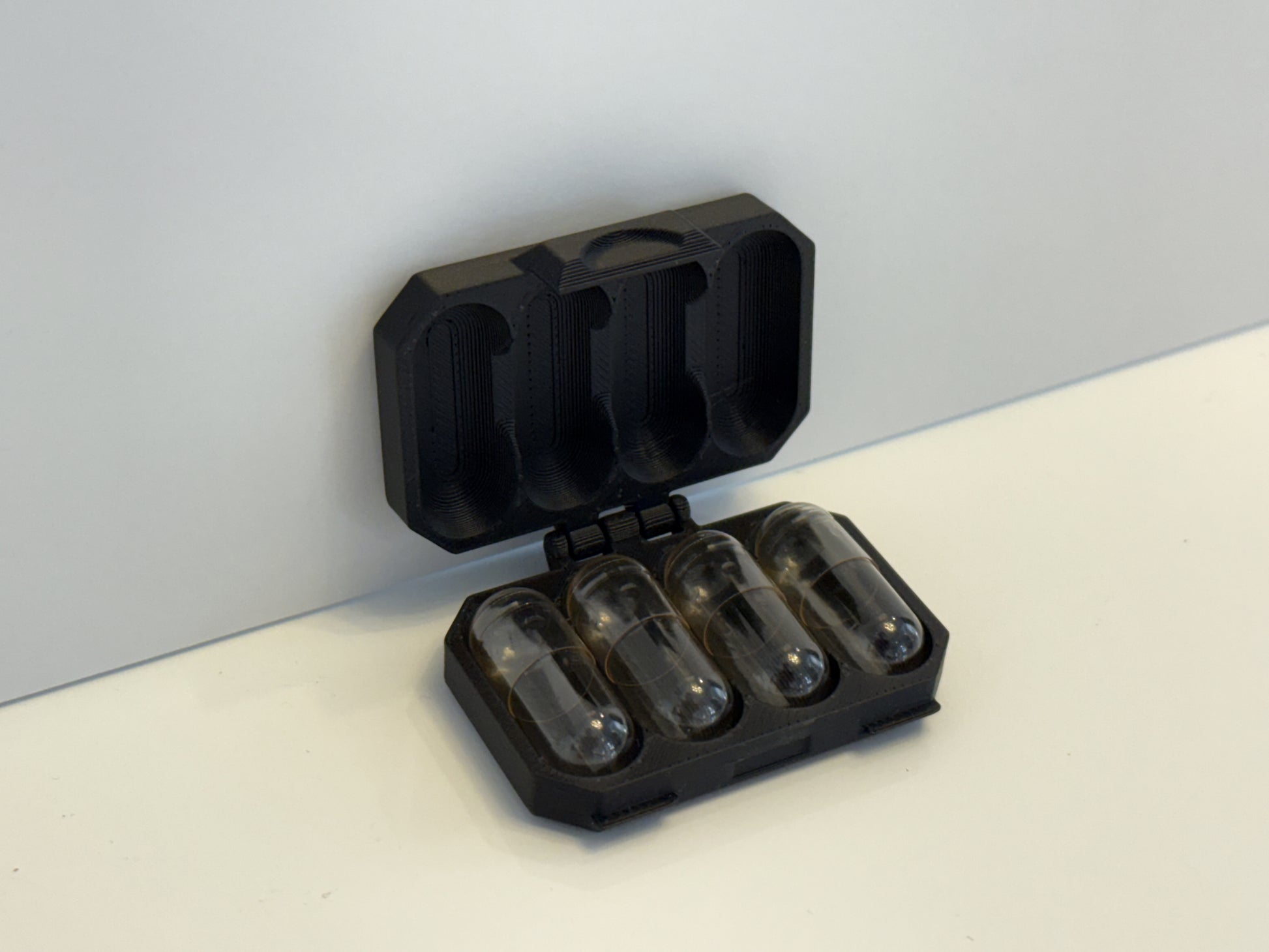 Capsule container with four (4) empty capsules inside